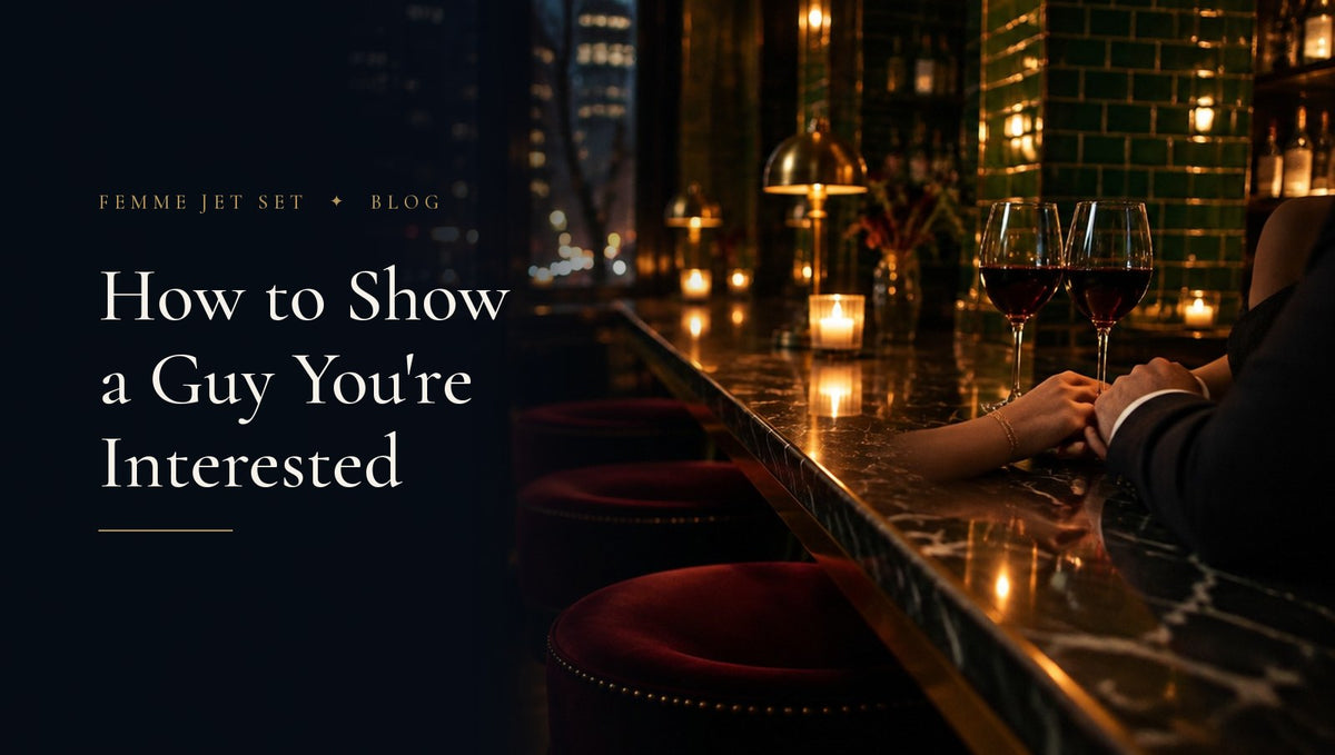 Candlelit West Village wine bar with two glasses of red wine and two hands touching, How to Show a Guy You're Interested cover
