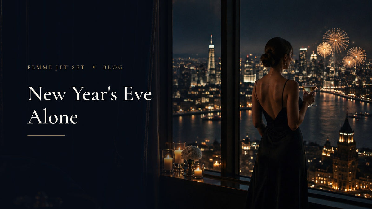 Woman in a black evening gown alone at a hotel window watching New Year's Eve fireworks